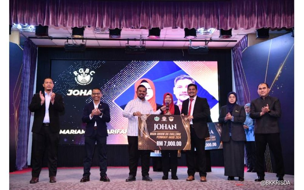 Manndzri (tiga dari kiri) menyampaikan hadiah kepada Mariam dan Tengku Iskandar yang memenangi tempat pertama.