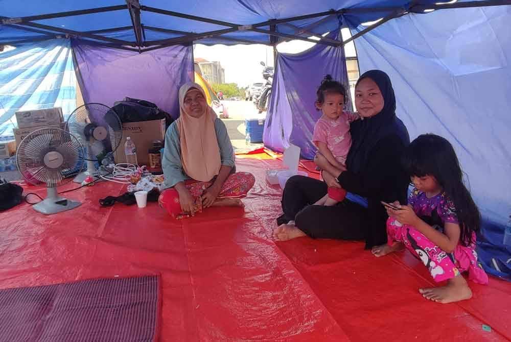 Aripiah dan Kausar antara sebahagian penduduk memasang khemah tepi jalan berikutan PPS terdekat penuh.