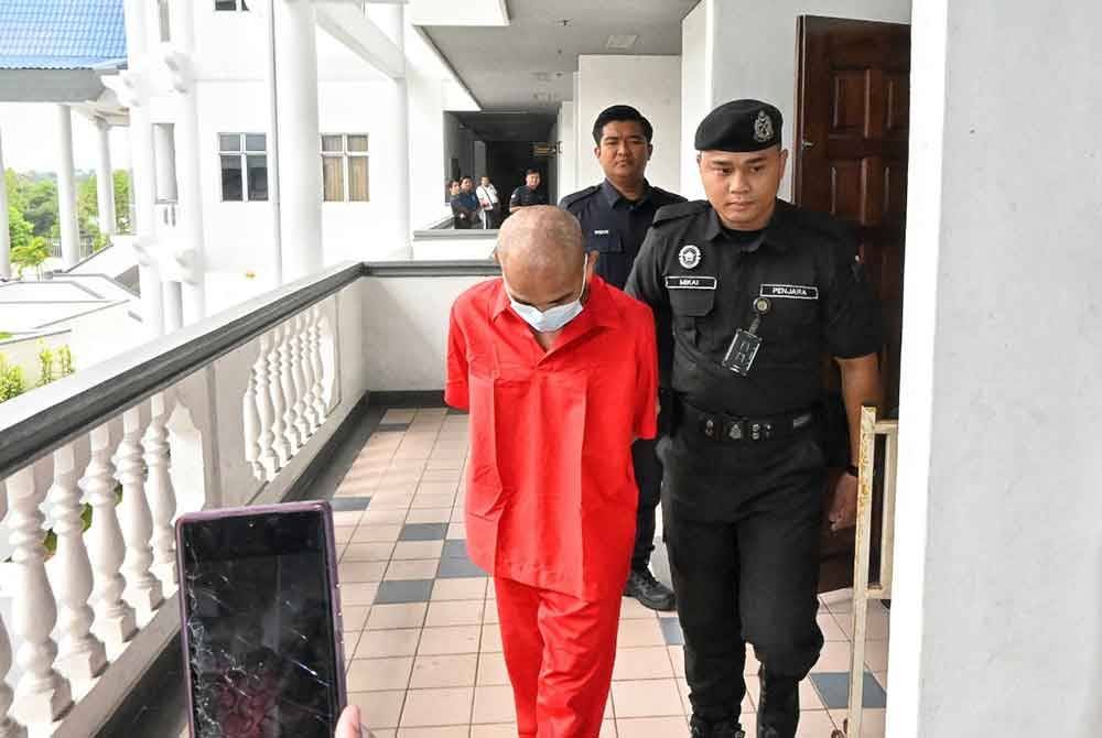 Zemi (kiri) ketika dibawa keluar dari Mahkamah Sesyen di sini, pada Selasa.