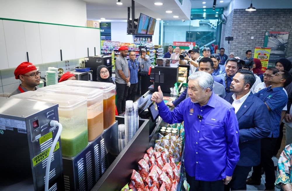 Ahmad Zahid menunjukkan isyarat bagus ketika sesi lawatan premis RisSMart24 di UOA Business Park, Shah Alam.