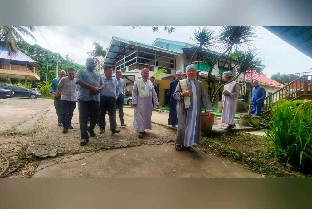 Syeikhuna Syeikh Muhammad Nuruddin (depan) ketika membawa tetamu yang hadir melawat maahad tersebut yang terletak di Janda Baik, Bentong.