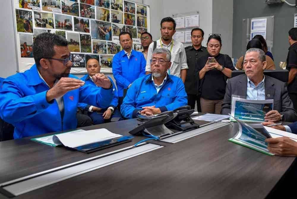 Fadillah Yusof (kanan) mengikuti taklimat berkaitan persiapan banjir oleh pihak TNB semasa melawat 'War Room Banjir' di Wisma TNB hari ini. Foto Bernama