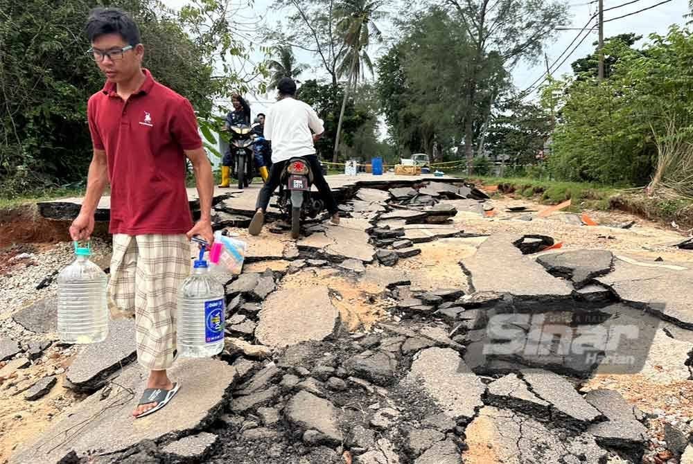 Penduduk terpaksa berjalan kaki bagi memunggah air. FOTO SINAR HARIAN-ADILA SHARINNI WAHID.