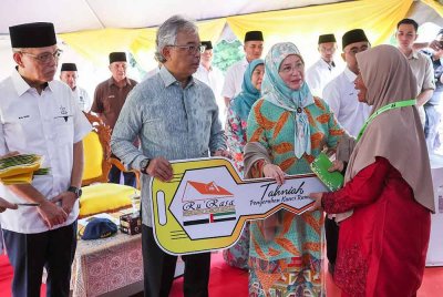 Al-Sultan Abdullah berkenan mengurniakan replika kunci rumah Ru'RASA kepada penerima, Rosnah Ab Razak, 56, (kanan) pada Majlis Pengurniaan Kunci Ru'RASA di Kampung Tanjung Gahai hari ini. - Foto: Bernama