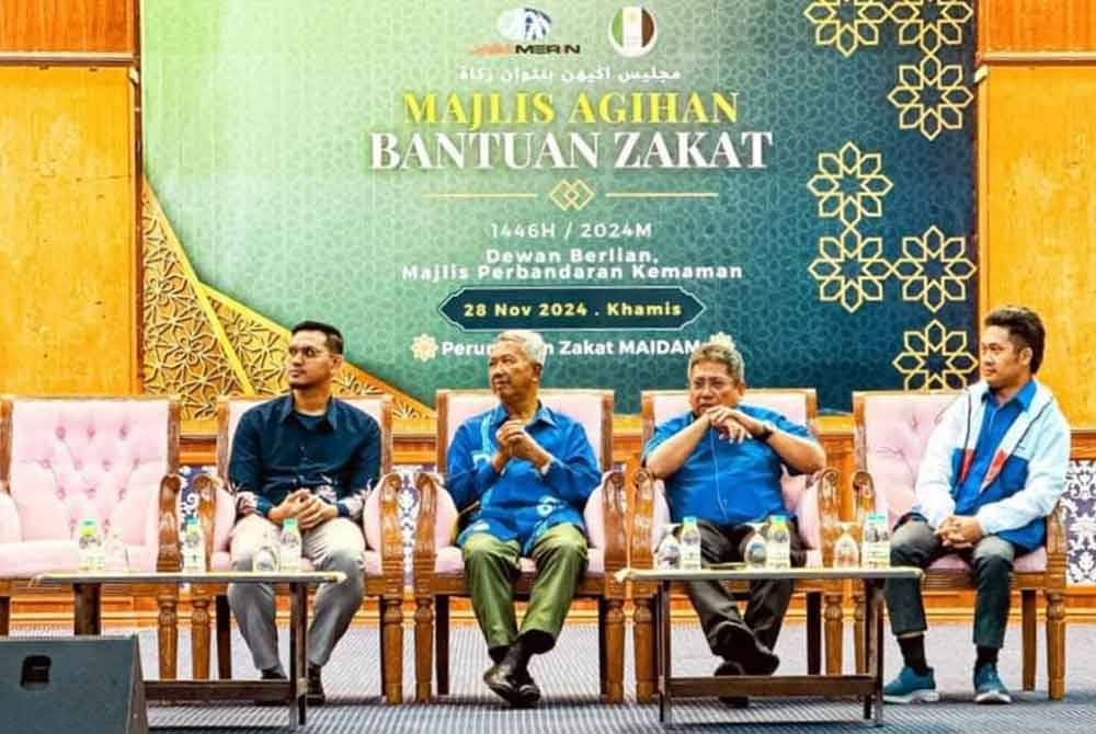 Muhammad Syarif (kiri) bersama Mokhtar (dua dari kiri) ketika hadir pada program agihan zakat di Dewan Berlian, Majlis Perbandaran Kemaman, baru-baru ini.