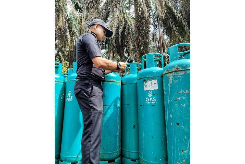Anggota penguat kuasa KPDN Pahang melakukan pemeriksaan terhadap tong LPG yang ditemui pada lori terbabit. Foto ihsan KPDN
