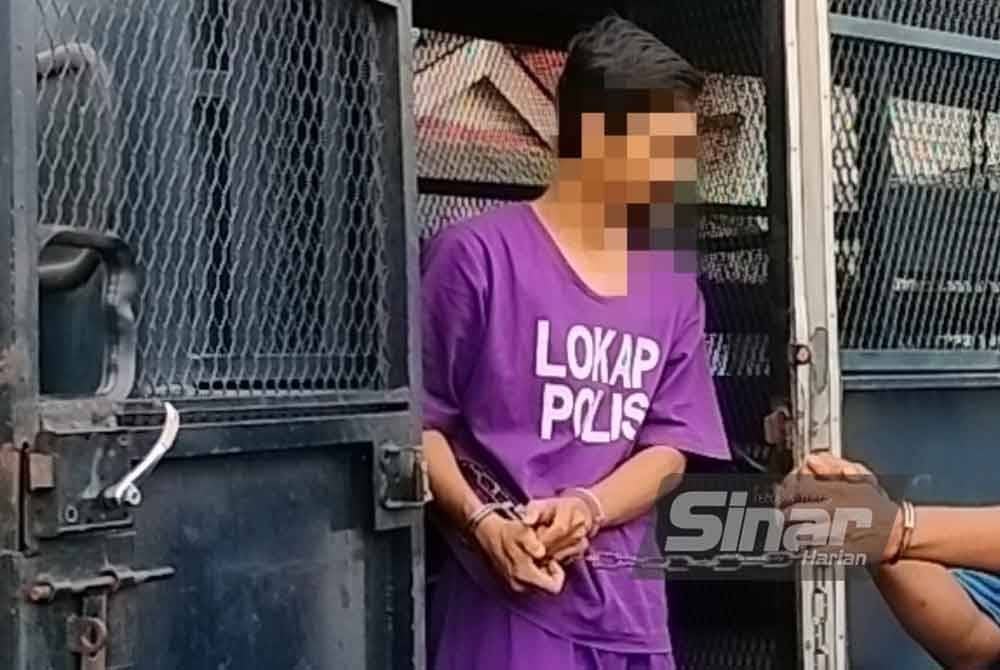 Suspek yang memakai baju lokap berwarna ungu tiba di pekarangan mahkamah dengan dikawal anggota polis pada jam 9 pagi.