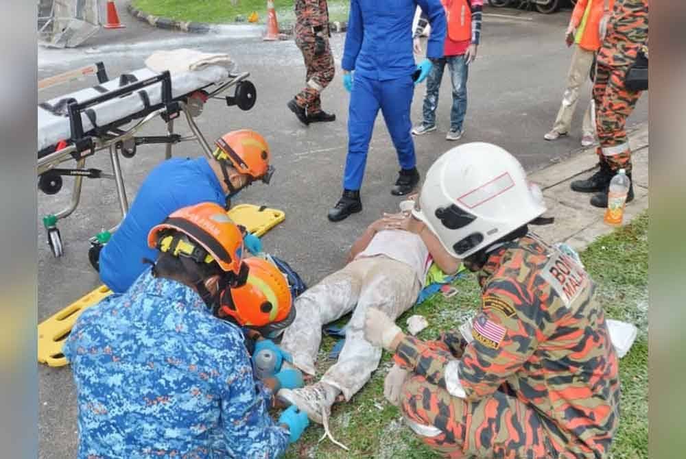 Anggota penyelamat memberi bantuan awal kepada mangsa.