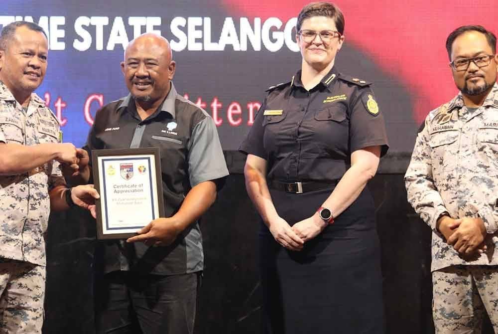 Mohd Zawawi (kiri) menyampaikan sijil penghargaan kepada wakil Persatuan Nelayan Kawasan (PNK) pada Majlis Penutupan Operasi Redback 19/2024 di Klang pada Khamis.