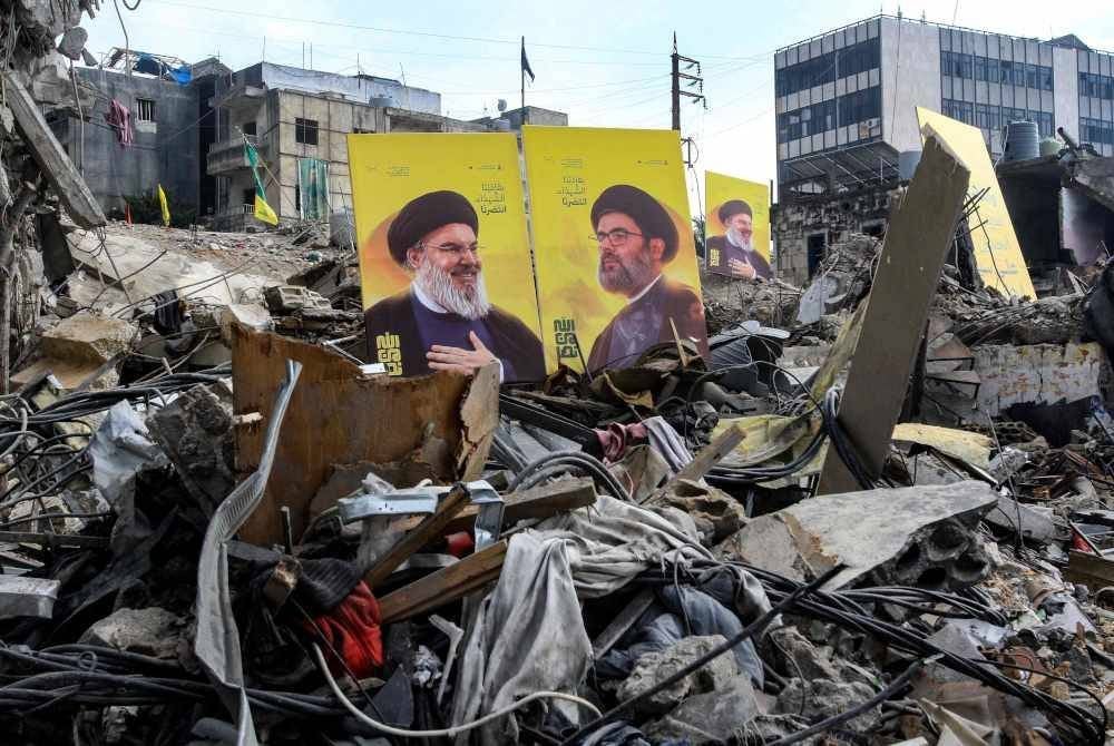 POSTER pemimpin Hizbullah yang terbunuh, Hassan Nasrallah (kiri) dan Hashem Safieddine diletakkan di tengah-tengah runtuhan bangunan selepas dibedil Israel. Foto AFP