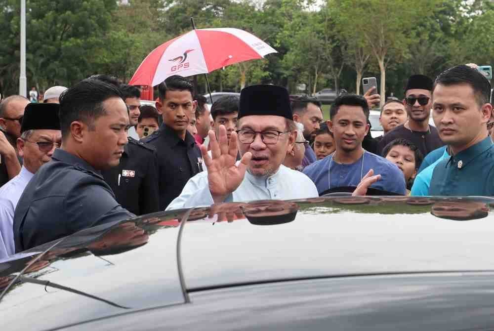 Anwar melambaikan tangan kepada para jemaah selepas menunaikan Solat Jumaat di Surau Al-Manar, Jalan P14, Presint 14 pada Jumaat. Foto Bernama