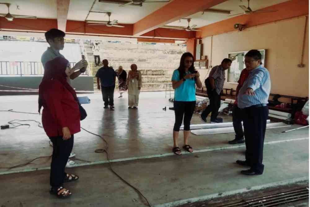 William (kanan) membuat tinjauan kerja baik pulih cerun di SK Tasik Puteri 2 yang siap sepenuhnya selepas runtuh pada awal tahun ini.