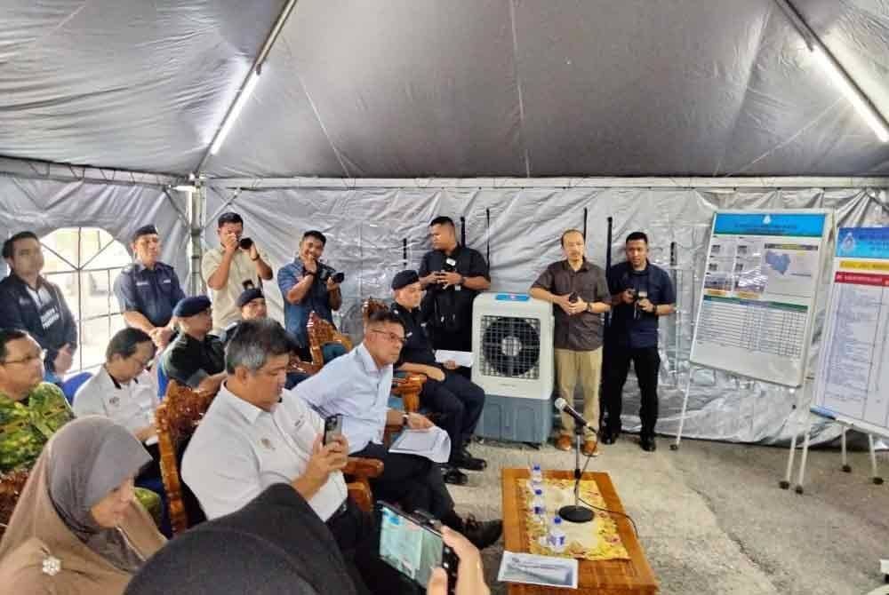 Saifuddin (tengah) mendengar talimat daripada Mohd Yusoff mengenai mengenai situasi banjir di Kelantan.