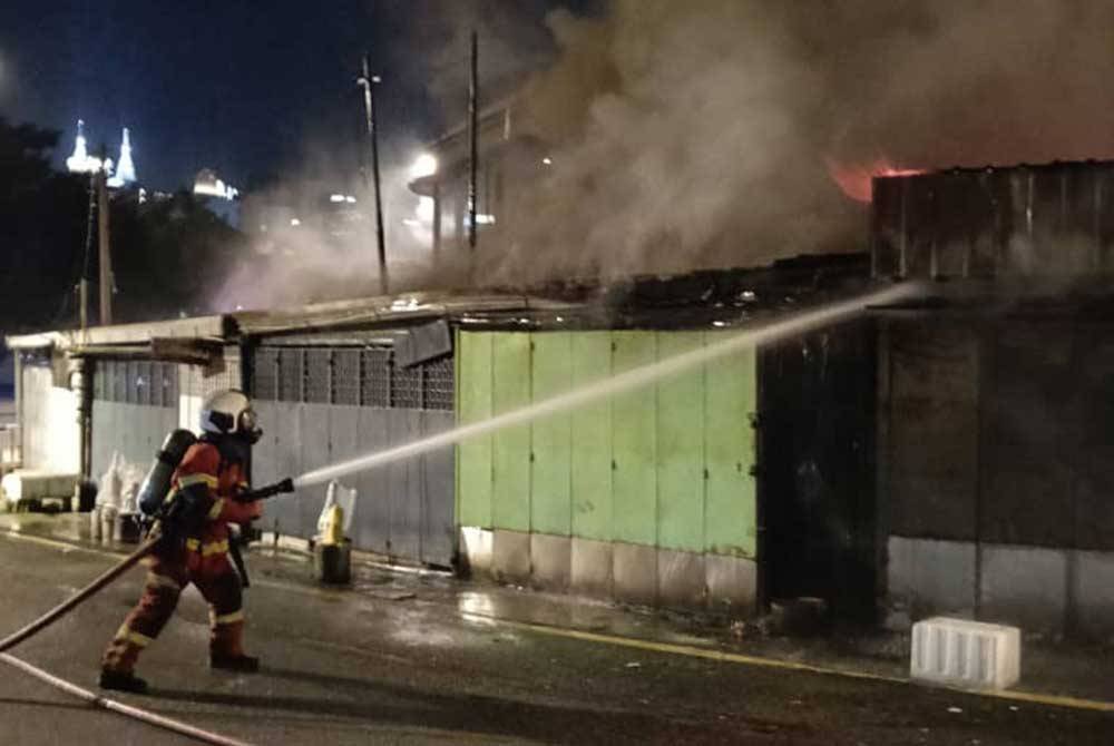 Anggota bomba sedang menjalankan kerja-kerja pemadaman di sebuah kedai ikan perhiasan yang terbakar pada Jumaat.