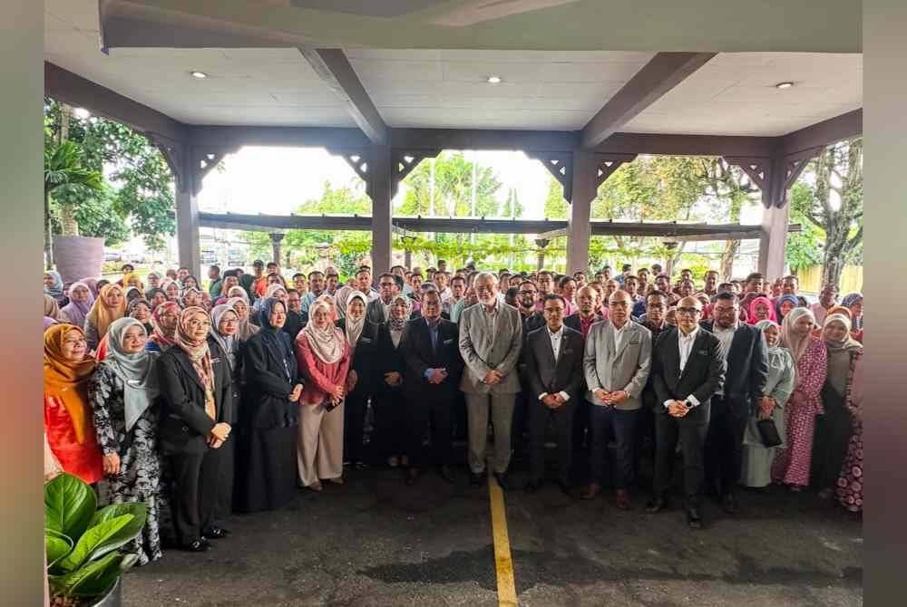 Khalid (lapan dari kanan) bergambar bersama kakitangan KADA di Lundang pada Ahad.