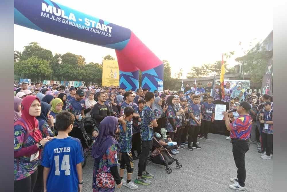 Peserta larian mendengar taklimat dari urusetia sebelum majlis perlepasan disempurnakan Mohd Fauzi.