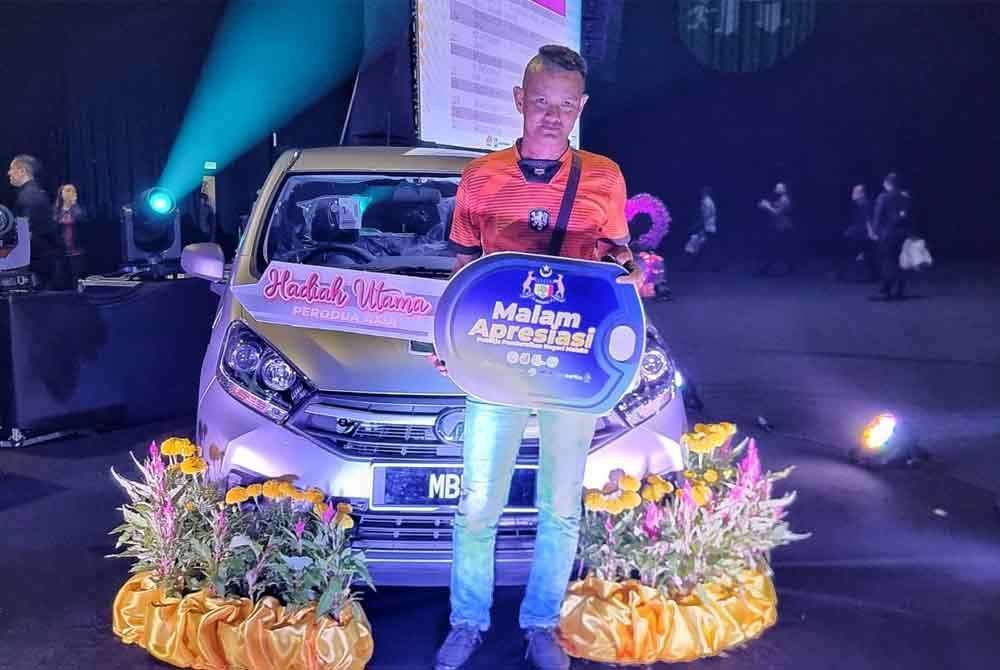 Rosly bergambar bersama kereta Perodua Axia pada Majlis Apresiasi Pekerja Pembersihan 2024 di Dewan MITC Ayer Keroh pada malam Ahad.