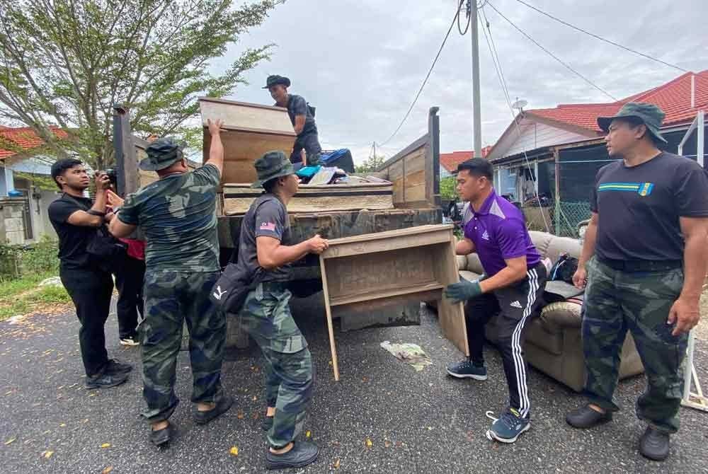 Zulkifli (dua dari kanan) serta yang lain untuk turut sama bermandi peluh membantu kerja-kerja membersih kawasan.