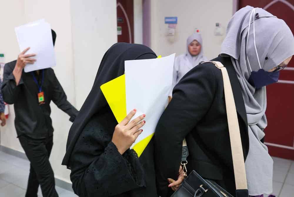 Dua mahasiswa yang juga anak kepada tukang urut (tengah) dan pasangannya (kiri) didakwa atas kesalahan khalwat di Mahkamah Tinggi Syariah pada Isnin.