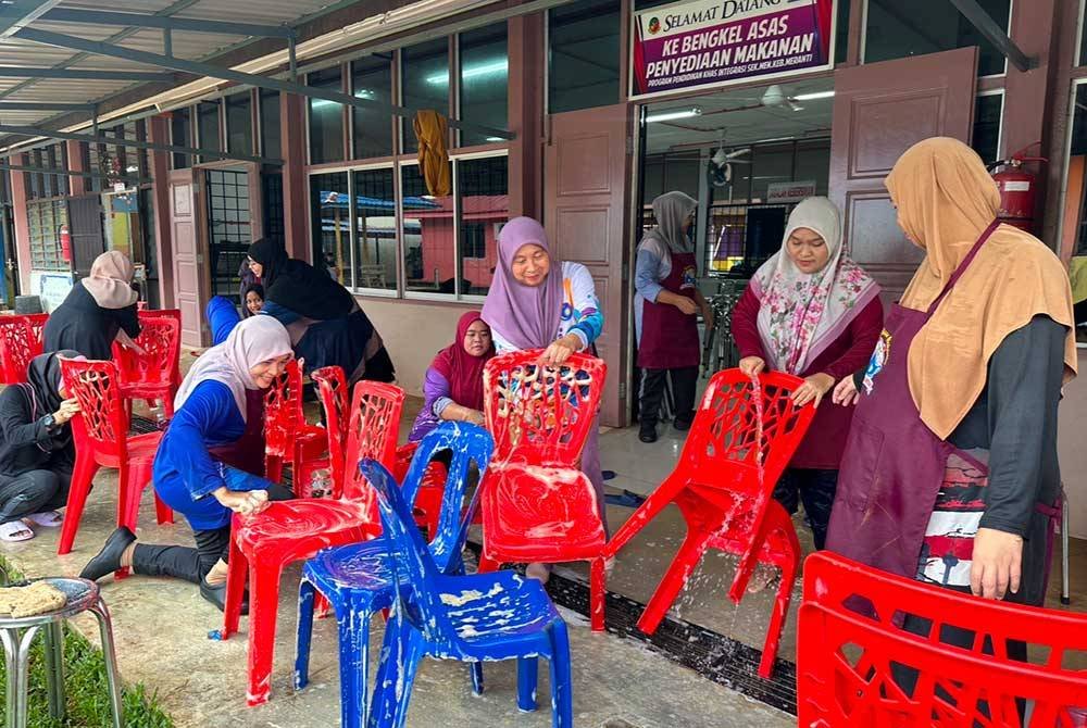 Para guru SMK Meranti yang sukarelawa membantu membersihkan kerusi untuk digunakan oleh calon.SPM.