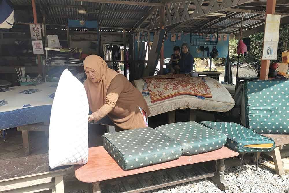 Cuaca panas dimanfaatkan sepenuhnya oleh Fatimah untuk menjemur barangan yang ditenggelami air.