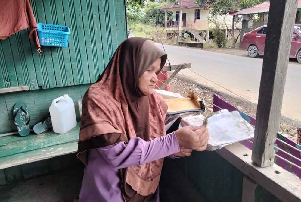 Fatimah membelek buku agama yang dijemur