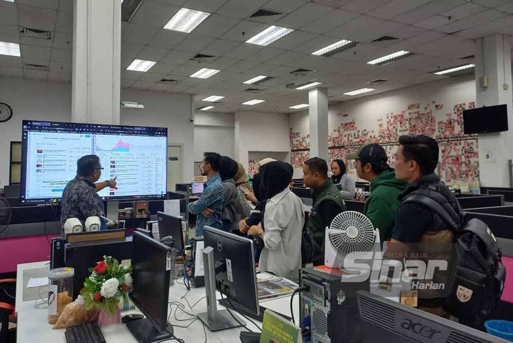 Zamri (kiri) memberi penerangan kepada editor dan wartawan cakaplah.com ketika lawatan ke Kompleks Kumpulan Media Karangkraf, pada Isnin.