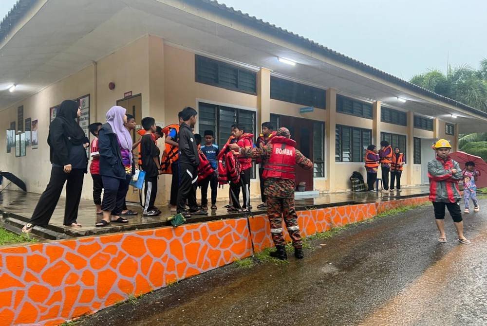 Seramai 29 murid, 14 guru dan empat kanak-kanak yang terperangkap dalam banjir di Sekolah Kebangsaan (SK) Padang Kubu, di sini diselamatkan anggota bomba. Foto BBP Cheneh
