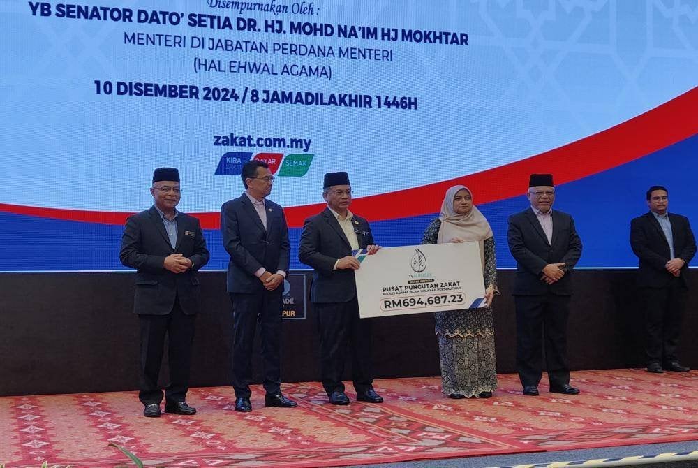 Mohd Na'im (tiga dari kiri) menerima zakat perniagaan daripada sebuah syarikat pada Majlis Zakat Korporat 2024 pada Selasa.