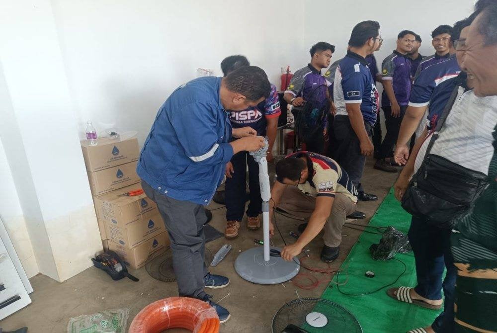 Kakitangan dan pelajar Institut Latihan Perindustrian (ILP) Kuala Terengganu membantu membaiki peralatan elektronik yang rosak akibat banjir.