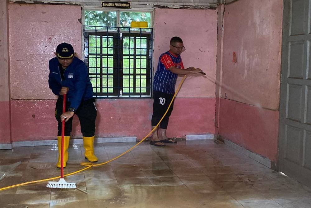 Mohd Azmawi Fikri (kanan) turut sama membersihkan Tabika Kemas Harmoni di Kampung Serongga, Pasir Mas pada Selasa.