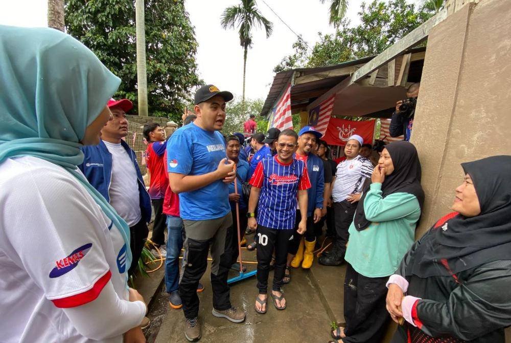 Dr Muhamad Akmal (tiga,kiri) bertanyakan khabar pada guru tabika semasa turun padang bergotong-royong membersihkan Tabika Kemas Harmoni di Kampung Serongga, Pasir Mas pada Selasa.