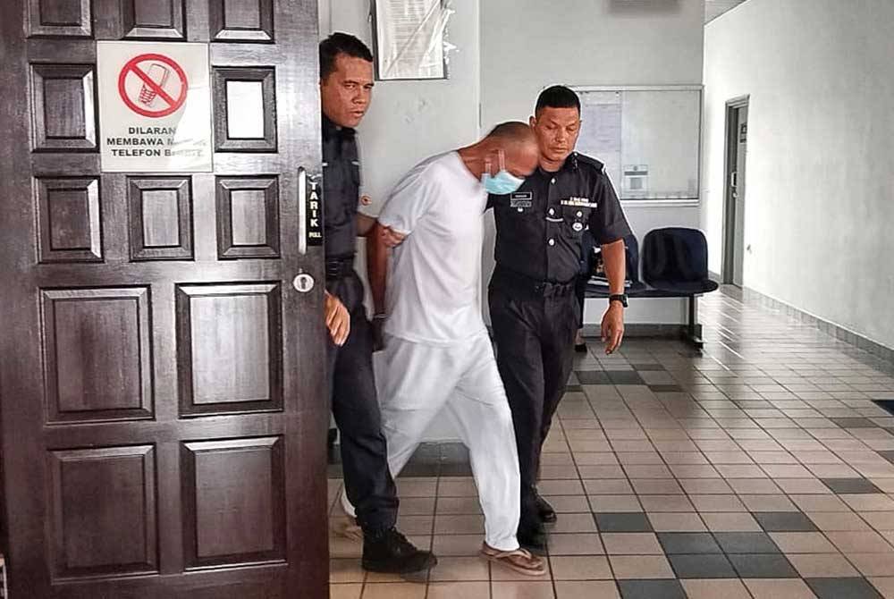 Ramlan (tengah) dibawa keluar dari Mahkamah Tinggi.