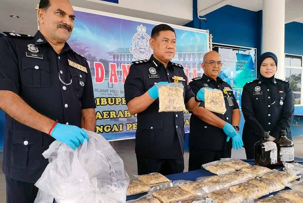 Wan Azharudin (dua kiri) menunjukkan dadah yang dirampas jenis heroin dan kafein.