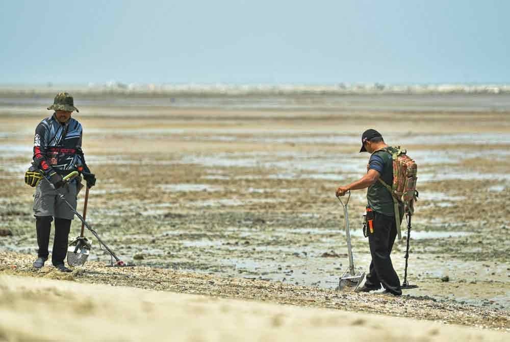 Dua orang penjejak logam melakukan aktiviti menjejak logam di Pantai Morib baru-baru ini. Foto Bernama