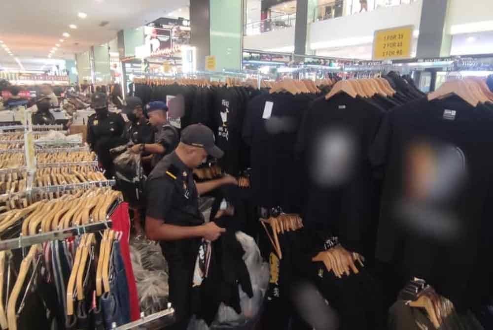Anggota KPDN melakukan pemeriksaan di salah sebuah premis di pusat beli-belah di Johor Bahru. Foto KPDN