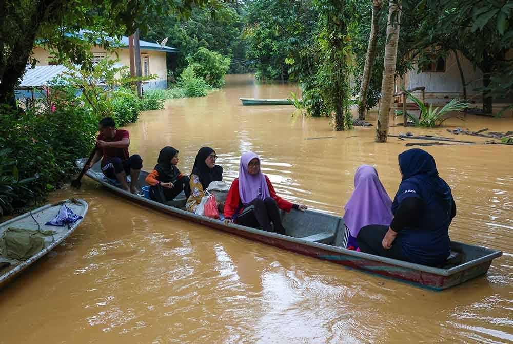 Penduduk menggunakan bot untuk melakukan aktiviti harian selepas perkampungan mereka dinaiki air berikutan hujan lebat yang melanda sejak Isnin ketika tinjauan di Kampung Limau Kasturi. Foto Bernama