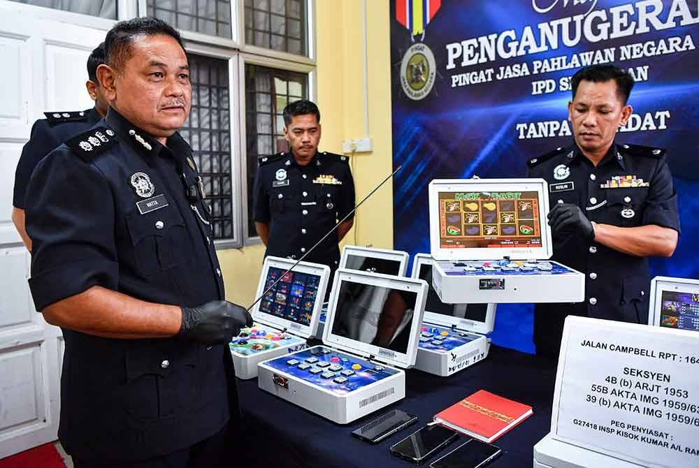 Mohamad Hatta (kiri) menunjukkan sebahagian rampasan mesin simulator pada sidang media di Ibu Pejabat Polis Daerah Seremban, pada Rabu. Foto Bernama