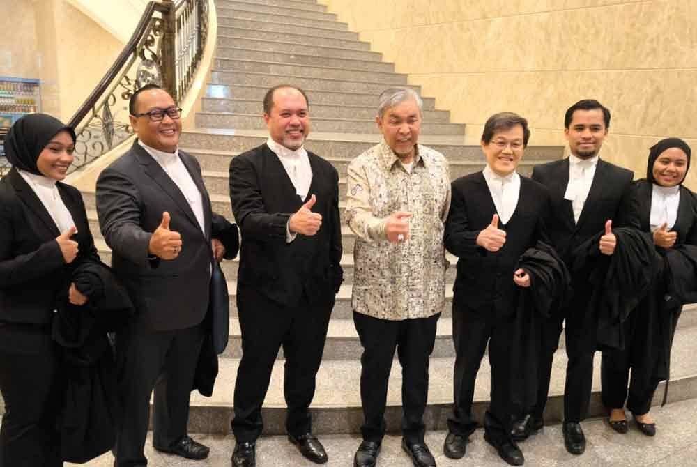 Ahmad Zahid (tengah) menunjukkan tanda bagus bersama barisan peguamnya, selepas Mahkamah Rayuan di Putrajaya pada Khamis, dimaklumkan AGC telah menarik balik rayuan atas pembebasannya bagi kes 40 pertuduhan menerima rasuah Syarikat UKSB berhubung Sistem VLN.