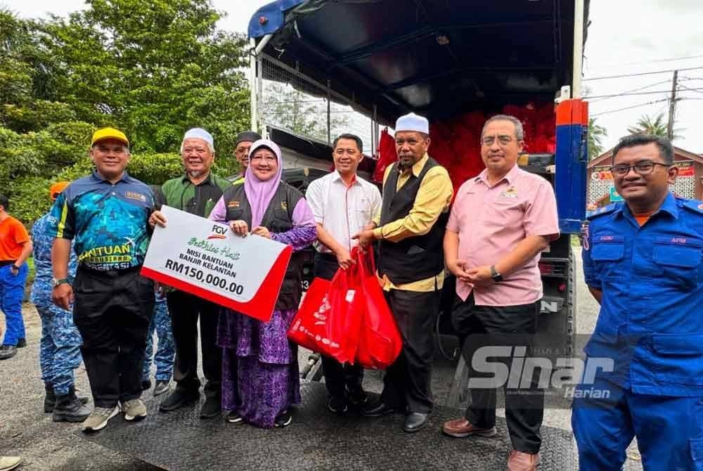 Wan Roslan (tiga dari kiri) menerima bantuan makanan daripada FGV yang akan diagihkan kepada mangsa banjir. FOTO SINAR HARIAN-ADILA SHARINNI WAHID.