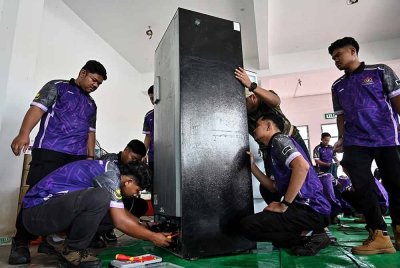 Sebahagian pelajar-pelajar Institut Latihan Perindustrian (ILP) membantu membaik pulih peralatan elektrik yang rosak milik mangsa banjir di Taman Desa Tanjung Damai (TDTD), Kuala Nerus. Foto Bernama