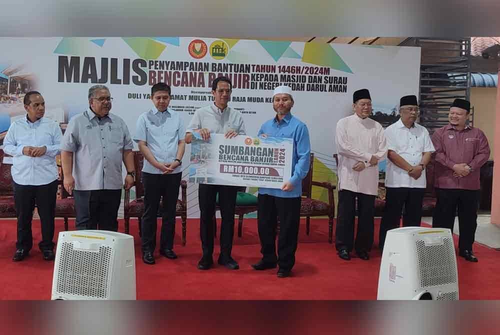 Tengku Sarafudin (empat dari kiri) berkenan menyerahkan cek cura kepada Pengerusi Surau Ihya'ulumuddin Kampung Semeliang, Misbahuddin Yussof (empat dari kanan) pada Majlis Penyampaian Bantuan Bencana Banjir kepada Masjid dan Surau di Kedah di Masjid Lutfi Kampung Suka Menanti,di sini,pada Khamis.