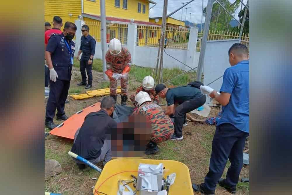 Anggota bomba mengalihkan mayat mangsa yang terkena renjatan elektrik ketika melakukan pemasangan panel solar di kawasan bangunan pejabat di Ranau.