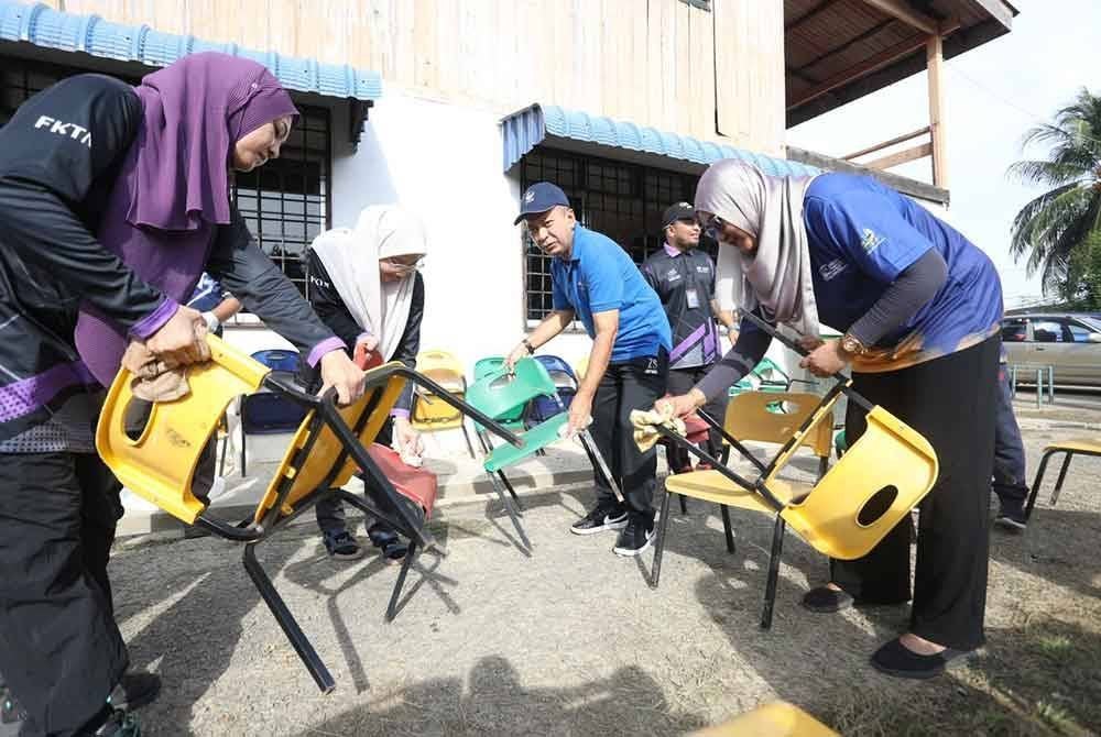 Zaliman (tengah) semasa turun padang bersama skuad Sentuhan Kasih Pasca Banjir UniMAP-UUM di Taman Tabung Haji, Alor Setar pada Khamis. FOTO UNIMAP