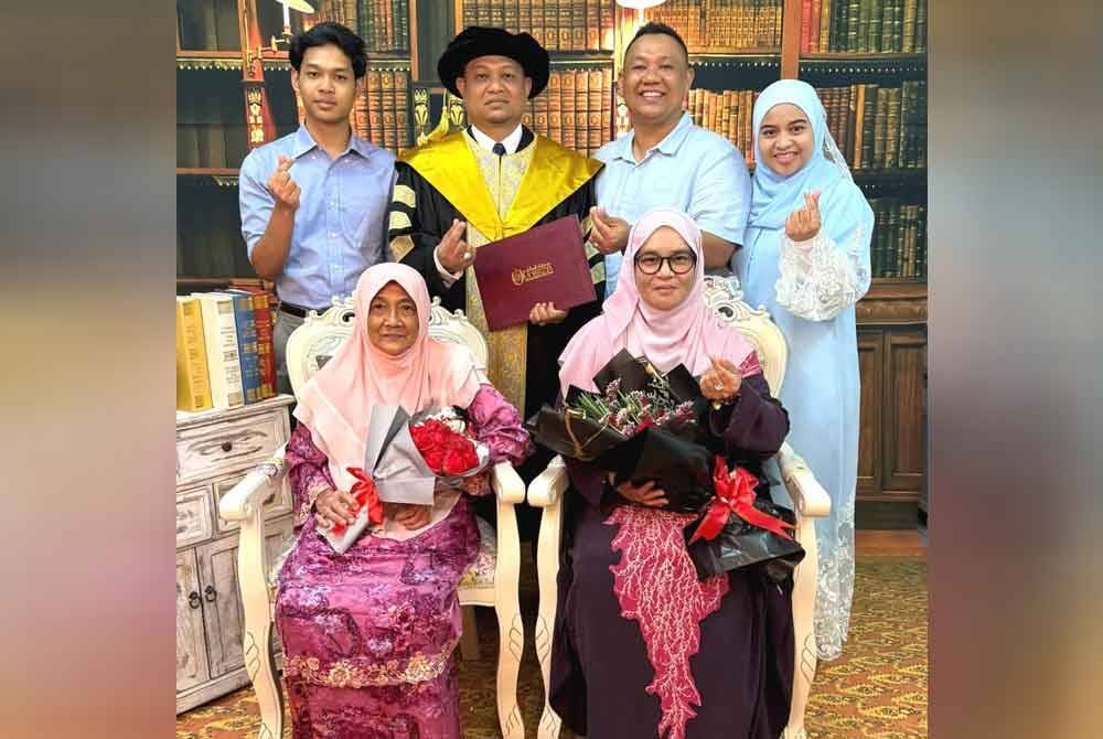 Kamarulzaman (berdiri, dua dari kiri) merakam gambar bersama anaknya, Kamarul Danish Adam (kiri), isteri, Zurina Mohamed (duduk, kanan) serta ahli keluarganya ketika Majlis Idul Ilmu (Istiadat Konvokesyen) ke-16 UniSZA November lalu.