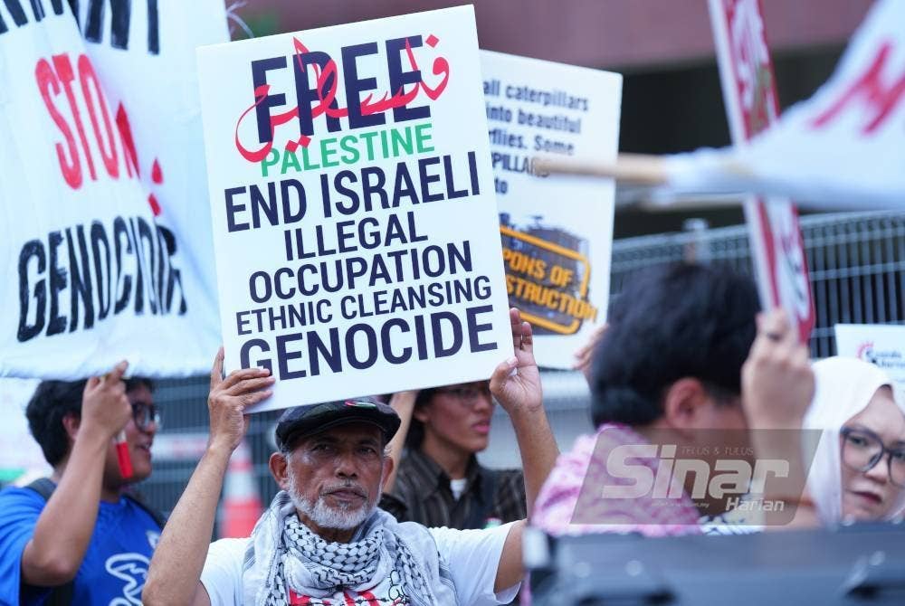 Aktivis memegang sepanduk tanda protes terhadap kekejaman Zionis di hadapan Kedutaan Jerman di Jalan Tun Razak pada Jumaat. Foto Sinar Harian MOHD HALIM ABDUL WAHID