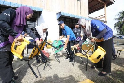 Zaliman (tengah) semasa turun padang bersama skuad Sentuhan Kasih Pasca Banjir UniMAP-UUM di Taman Tabung Haji, Alor Setar pada Khamis. FOTO UNIMAP