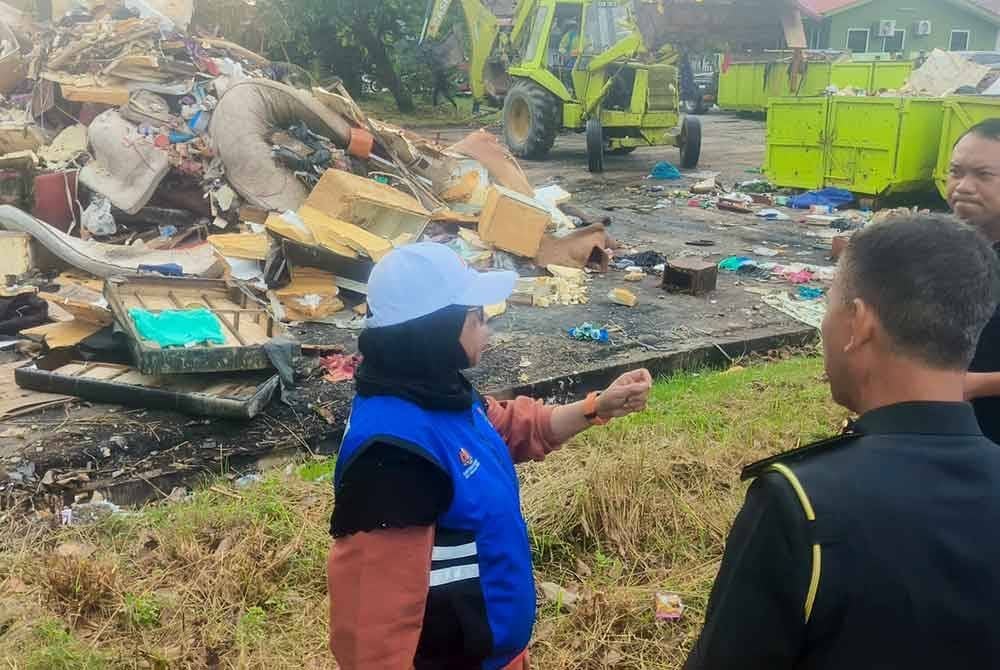 Aiman Athirah (kiri) semasa turun padang meninjau pembersihan dan dan pengurusan pasca banjir di Taman Aman, Alor Setar pada Ahad.