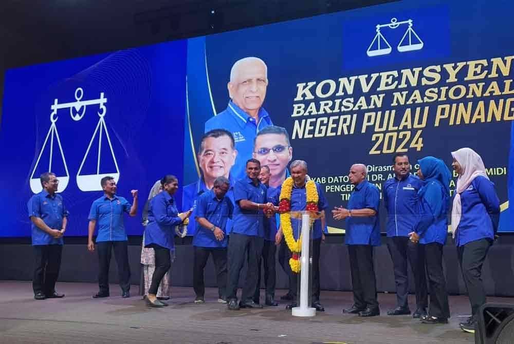 Ahmad Zahid menerima kalungan bunga malai dari Pengerusi MIC Pulau Pinang, Datuk J Dhinagaran selepas melancarkan Konvensyen BN Pulau Pinang, pada Ahad.
