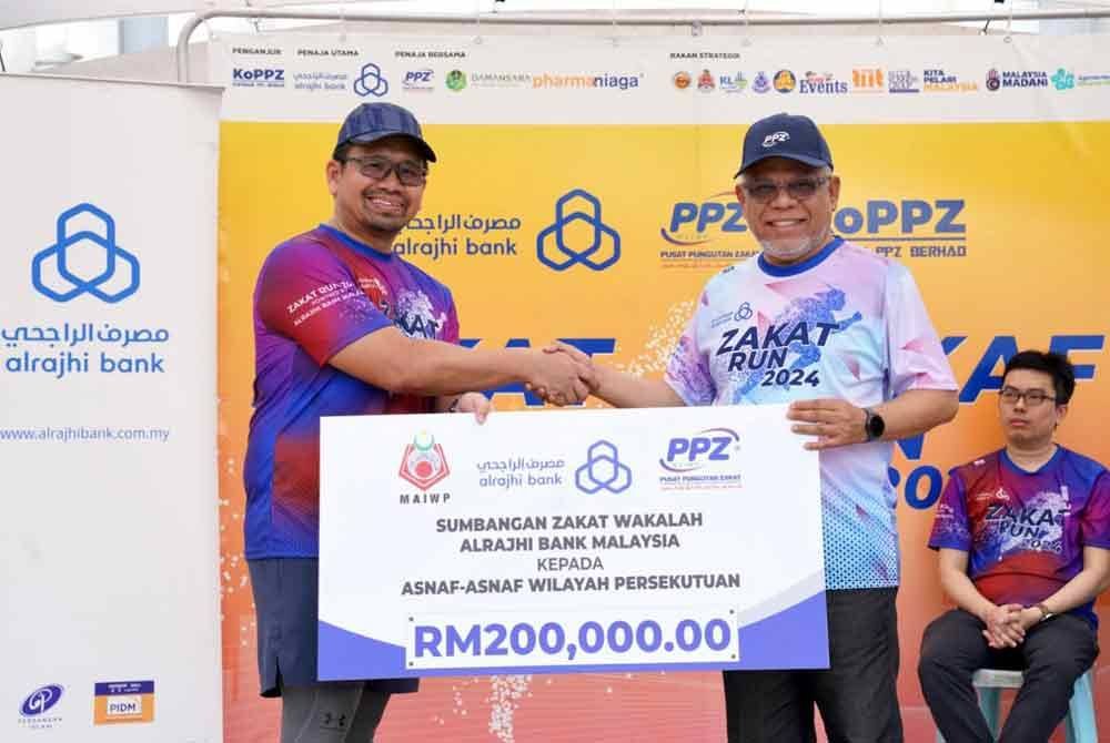Abdul Hakim (kanan) menerima wakalah bernilai RM200,000 ketika program Zakat & Wakaf Run 2024 di Dataran DBKL pada Ahad.